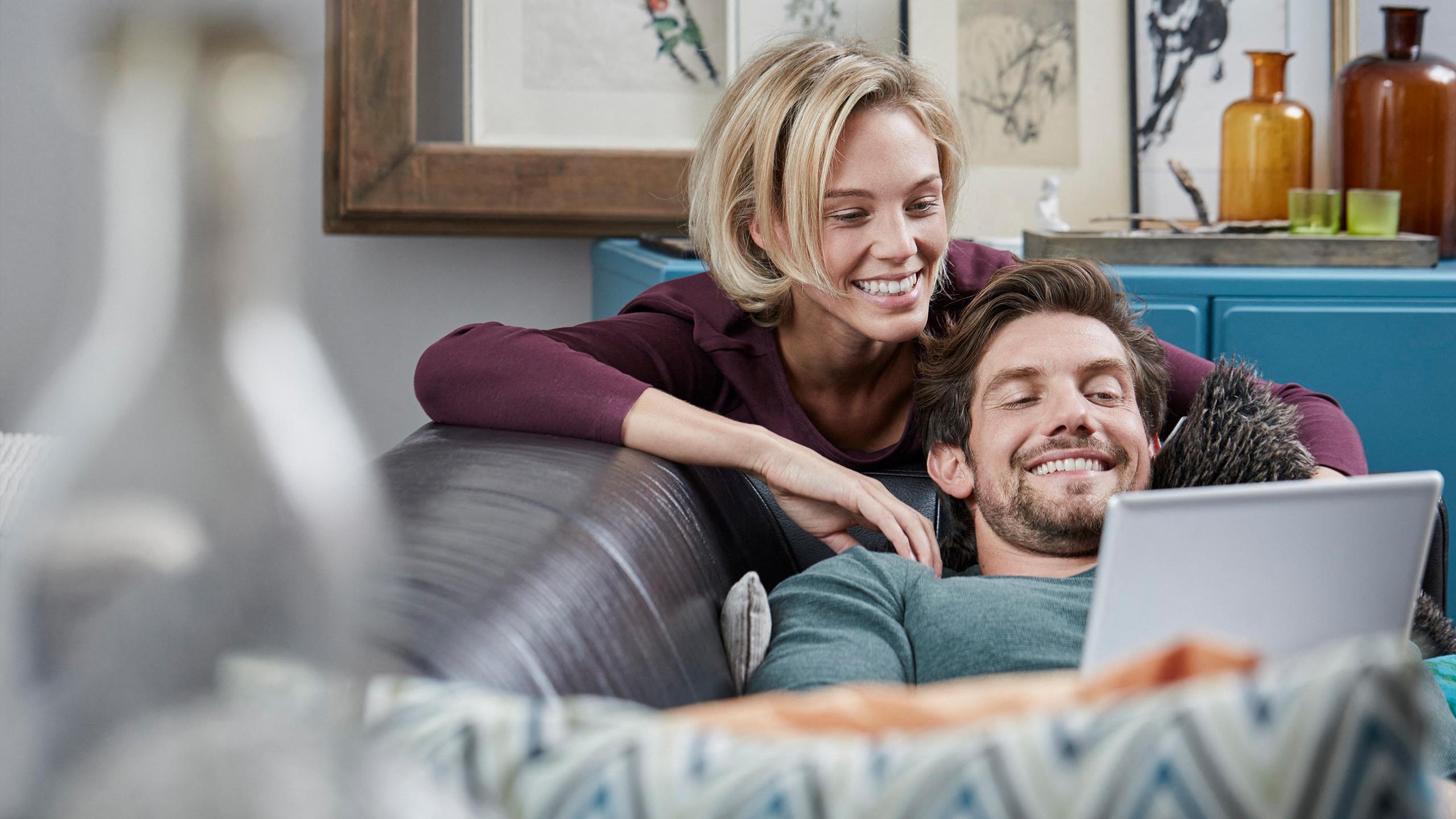 Un couple est en train de faire une recherche sur un investissement immobilier à la montagne sur un ordinateur portable