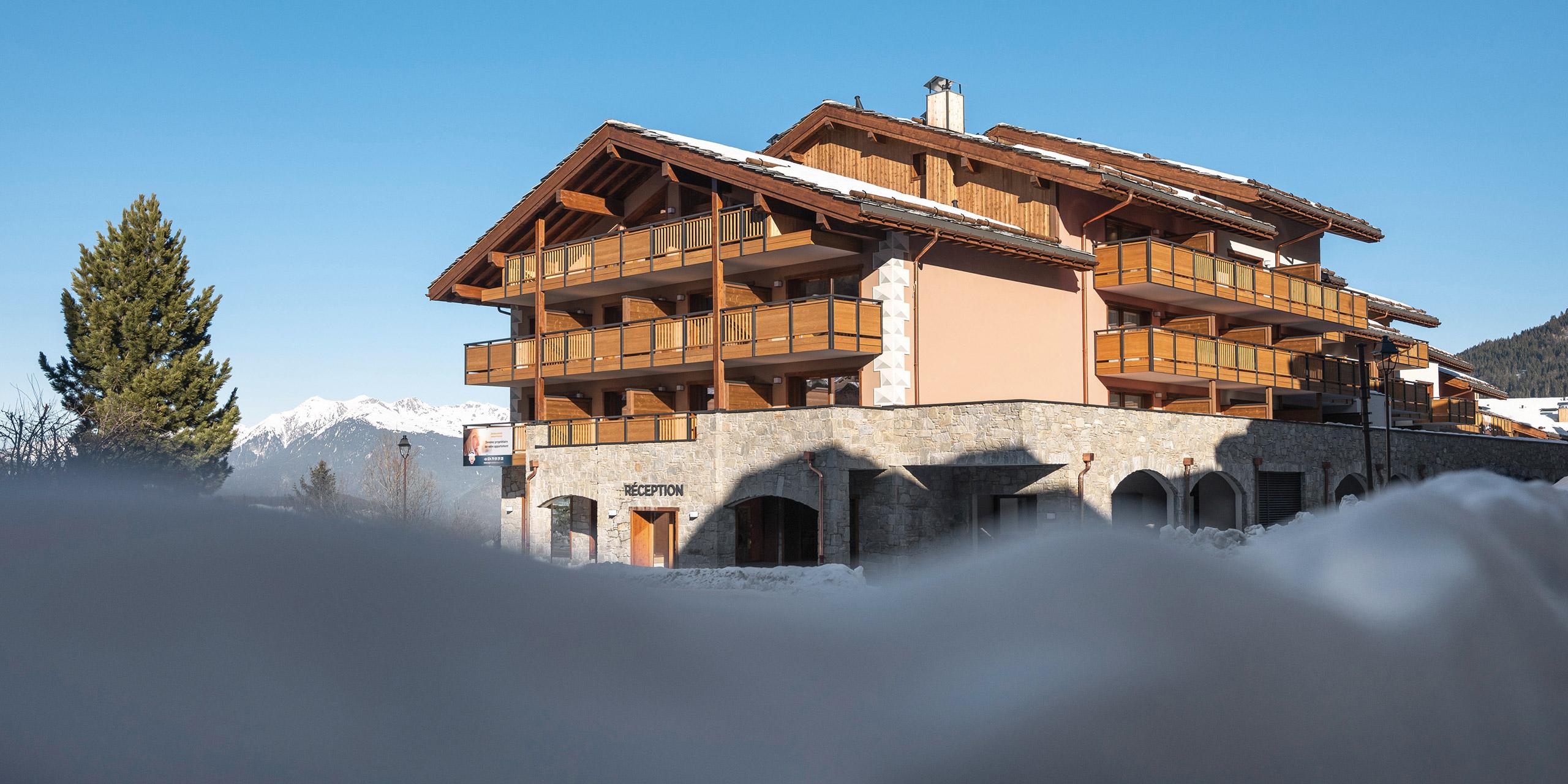 Vue de la résidence Akoya à Valmorel depuis l'extérieur dans un décor enneigé