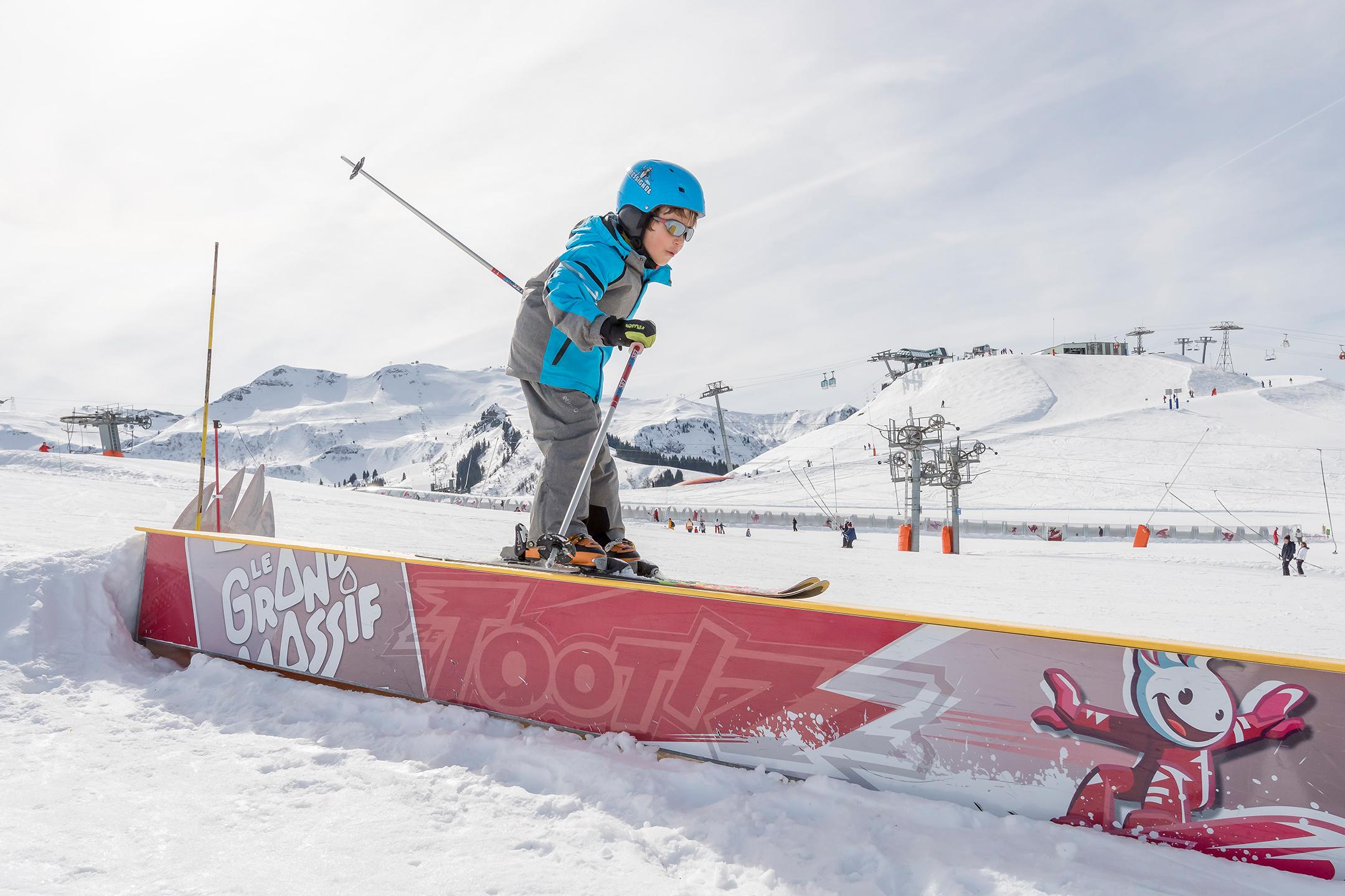 enfant sur une bar de slide en ski sur les pistes du Grand Massif