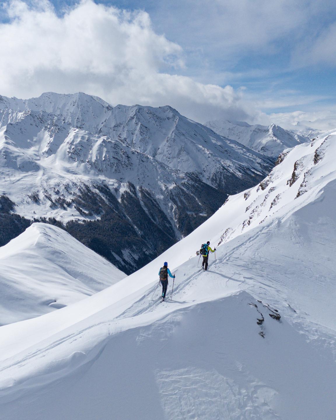 Deux personnes font du ski de randonnée sur une crète en Haute Maurienne